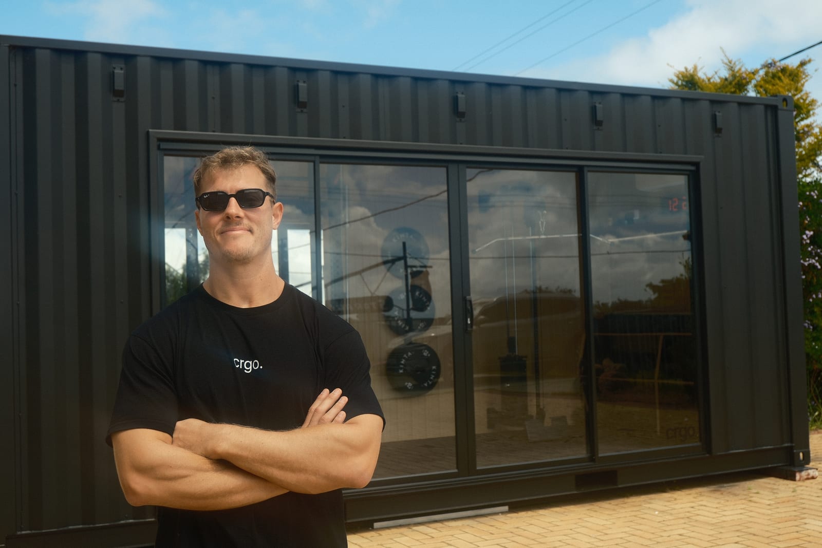The crgo founder standing in front of a crgo unit, arms folded