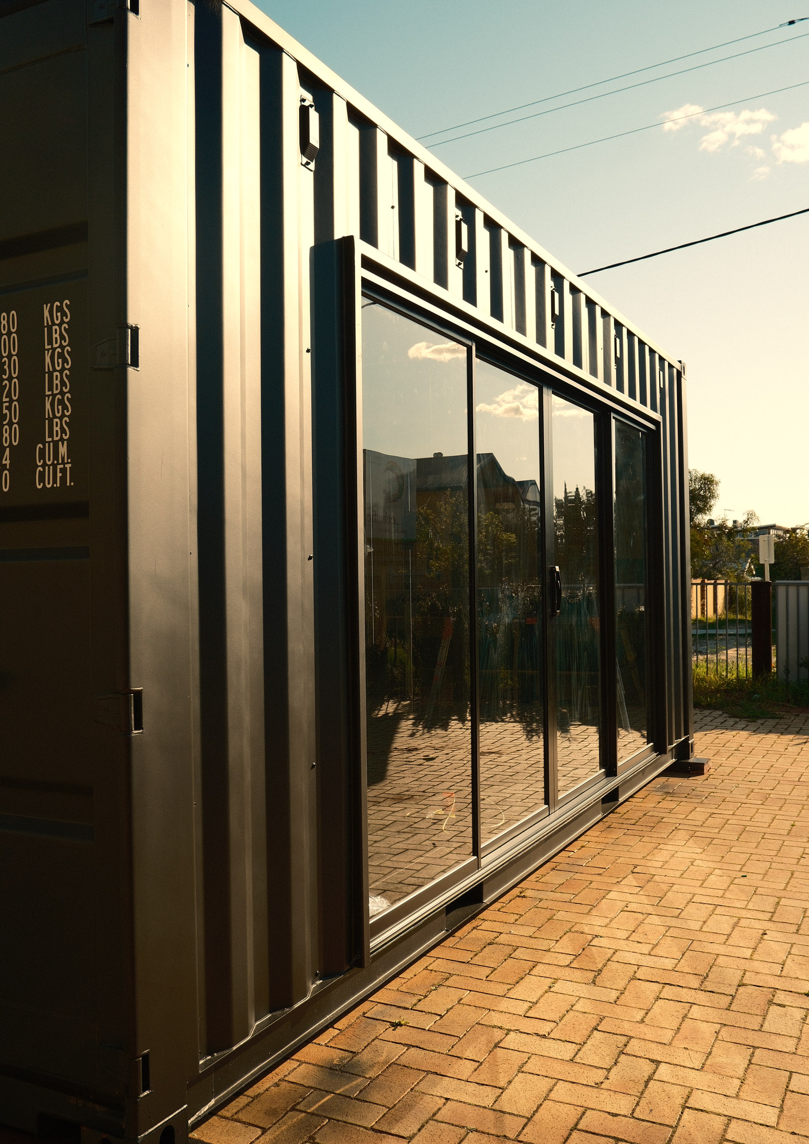 A crgo container gym sited on paving, glazed sliding doors along its long wall